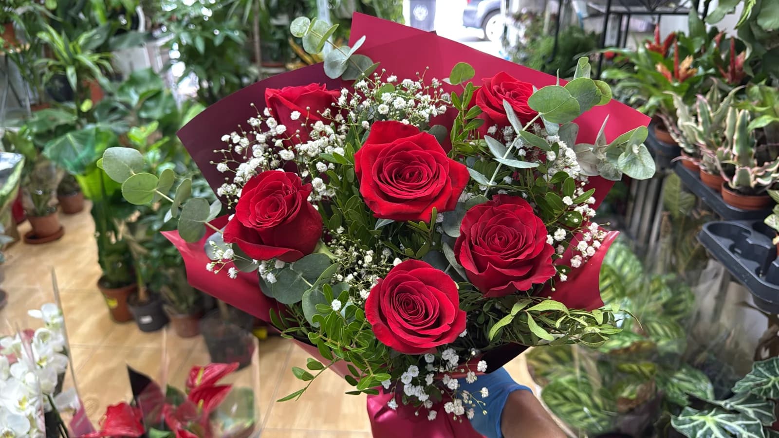 Ramo de rosas rojas con paniculata en papel negro y blanco con lazo