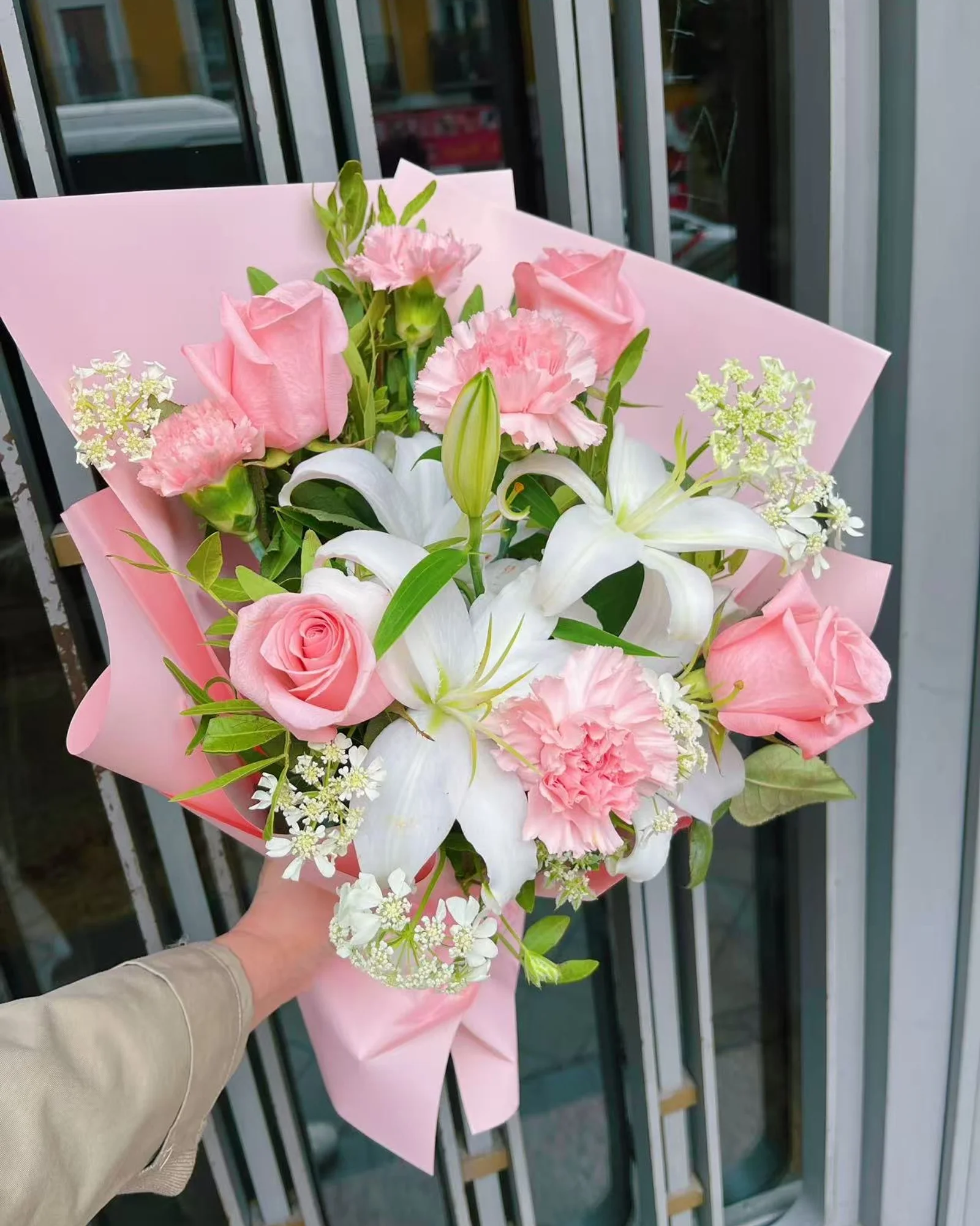 Ramo Ternura de rosas y claveles rosa empolvado con lirios blancos en papel coreano rosa